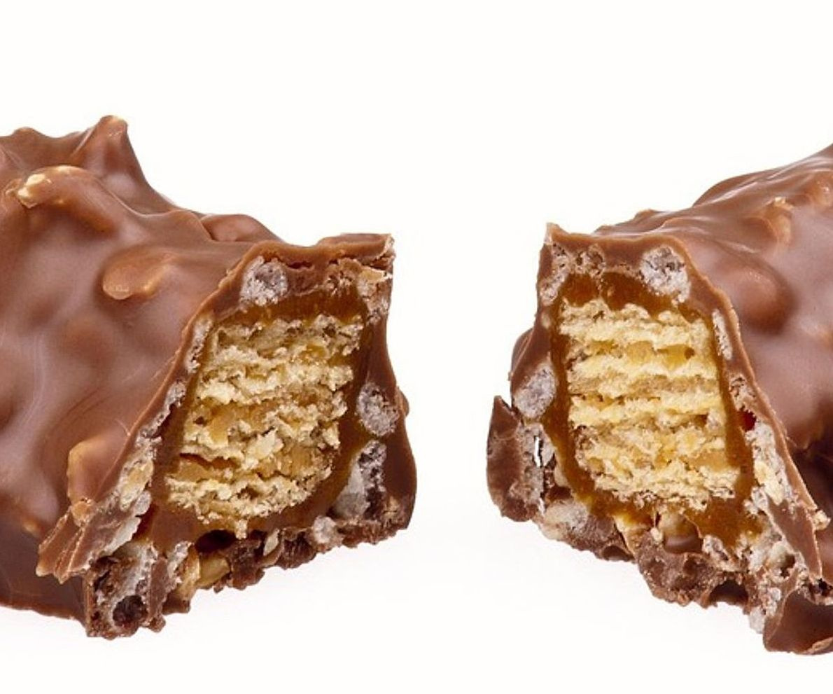 Hands packing premium chocolates and sweets into gift boxes